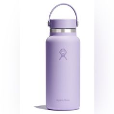 the hydro flask water bottle is purple and has a handle on it's side