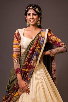 Cream base attached cancan lehenga with village kalamkari hand painted patterns and embroidery. Paired with padded cream blouse embroidered with glass beads and olive green printed dupatta with contrast border. - Aza Fashions Navratri Gown, Hand Painted Lehenga, Painted Lehenga, Kalamkari Dupatta, Cape Lehenga, Cancan Lehenga, Chikankari Lehenga, Kurta Lehenga, Lehenga Pattern