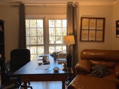 a living room filled with furniture and a wooden table in front of a large window