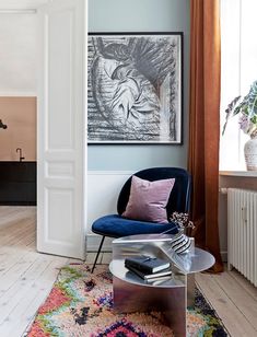 a living room with a blue chair and rug