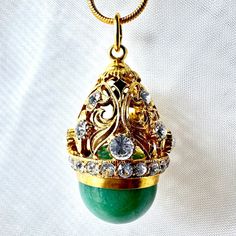 This magnificent, high-fashion handmade large pendant was inspired by and designed in a Faberge style. The 14mm natural green jade ball is set in  24k gold-plated 925 sterling silver top with a circular baroque art elements design of leaves. They are decorated with 2mm-4mm clear bright Premium Crystals. A chain of 2mm Premium Crystals separates the decorative top and the genuine green jade, giving the pendant a unique accent and strong contrast. The height of the pendant is approximately 1.3-inch and it comes with a gold-plated 24-inch snake chain. The jewelry box is included. I am a professional jewelry designer, who graduated from Saint Petersburg's Art and Design Academy. Immigrating to the USA, I brought back Faberge's style and traditional art with a twist. The egg is a universal symb Art Baroque, Faberge Egg, Elements Design, Art Elements, Baroque Art, Faberge Eggs, Professional Jewelry, Silver Tops, Elements Of Art