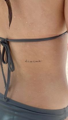 a woman's stomach with the word love tattooed on her lower back and side