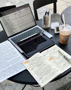 an open laptop computer sitting on top of a table next to a cup of coffee