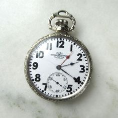 "This is a rare antique special production Railroad grade 21 Jewel model 99P Ball Watch Co. pocket watch.  This watch has a 14K white gold case.  It was produced in Cleveland, Ohio in 1927 with a serial number of B628315.  This watch, with an extra read hand, is known as a two time-zone hand-set with a 2-hour interval allowing a reading for two time zones two hours apart.  This feature was undoubtedly handy for managing railroad timetables more efficiently as it provided for every time zone in t Collectible Polished Pocket Watch, Antique Polished Pocket Watch, Collectible White Gold Round Watch, Antique Round Pocket Watch With Polished Finish, Vintage Pocket Watch For Anniversary With Polished Finish, Vintage Pocket Watch For Anniversary, Classic Silver Engraved Pocket Watch, Vintage Pocket Watch With Polished Finish, White Chronometer Pocket Watch As Gift