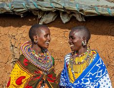 two women in brightly colored clothing standing next to each other