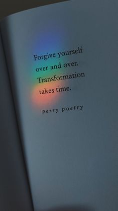 an open book with a rainbow light on the cover and some words written in it