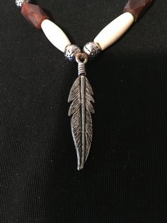 This is a tribal inspired necklace with white genuine buffalo bone beads and brown buffalo horn beads with a stainless steel  feather on a strand of deer sinew. Bone Color Bohemian Adjustable Necklace, Bohemian Bone-colored Necklace For Festivals, Inspired Necklace, Bone Beads, Beaded Necklaces, Horn, Buffalo, Bones, Deer