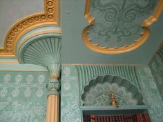 an ornately decorated room with blue walls and gold trim