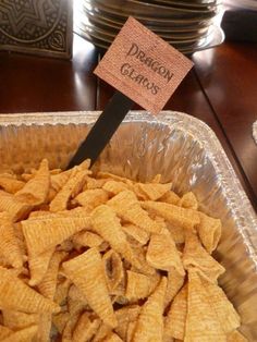 a container filled with cheetos sitting on top of a table next to plates