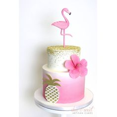 a pink and white cake with a flamingo decoration on the top is decorated with pineapple