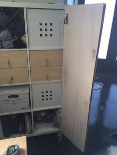 an open cabinet with drawers and baskets in it