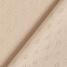 a close up shot of the textured fabric on a beige sweatering material, which is very soft