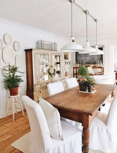 a wooden table surrounded by white chairs