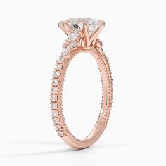 a rose gold engagement ring with an oval shaped center stone surrounded by small round diamonds