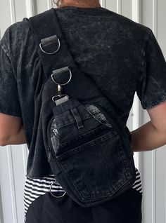 the back of a person wearing a black denim backpack with metal hardwares on it