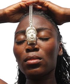 a woman with a white mask on her head and a chain attached to her forehead