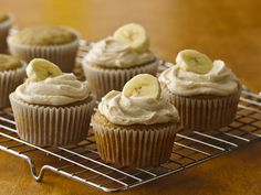 cupcakes with frosting and banana slices on a cooling rack