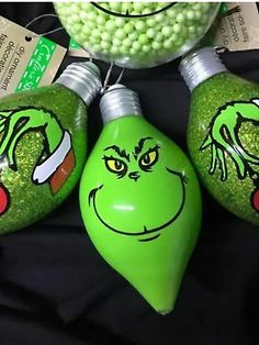 three green christmas ornaments with grin face on them