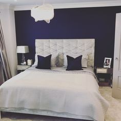 a white bed sitting in a bedroom under a chandelier