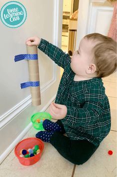 a little boy playing with toys on the floor in front of a door and an arrow pointing to it