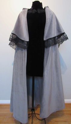 This elegant victorian style cloak is perfect whether you're going Christmas caroling, making a steampunk outfit, or just want something elegant and warm to wear as the weather cools. This grey velvet has a luxurious texture to it and the half-circle shape of this cloak gives it a classic drape. The lace edged capelet really gives this piece its historical flair.  Dimensions:  Front Length: 45.5" Back Length: 44.5" Capelet Front Length: 16" Capelet Back Length: 21.5" Hood Height: 14.5" Neck Circumference: 28.5" Made in USA from 100% Polyester Machine Wash Cold, Tumble Dry Low, Iron on Low if necessary. The goal for my shop is to keep prices low for you so I recycle fabrics to keep my costs down. I always make sure that any fabrics I use are washed and are in good condition. Return Policy: Winter Velvet Costume Outerwear, Velvet Outerwear For Costume, Elegant Velvet Outerwear For Costume, Winter Velvet Outerwear, Fitted Gothic Cape For Costume, Elegant Formal Halloween Outerwear, Elegant Formal Outerwear For Halloween, Fitted Winter Cape For Costume Party, Fitted Fall Cape For Costume