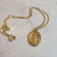 "This beautiful necklace features a stunning gold Italian Miraculous Medal on an 18\" chain. I have been making rosaries for decades, taught by one of the best crafters in the field. This rosary is handmade using a time-tested, intricate wire-wrapping technique, so it extremely durable meant to last a lifetime. It makes a truly meaningful gift for a baptism, wedding, or other faith celebration. DETAILS ⚬ Gold Italian Miraculous Medal ⚬ 18\" Chain ⚬ Includes free prayer card. ⚬ Free shipping. ⚬ M Yellow Gold Rosary With Miraculous Medal As Gift, Gold Spiritual Rosary With Miraculous Medal, Miraculous Medal Round Pendant Necklace As Gift, Miraculous Medal Round Pendant Necklace For Gift, Gold Medallion Necklace With Lobster Clasp As Gift, Gold Round Pendant With Miraculous Medal, Gold Oval Pendant Spiritual Jewelry, Gold Miraculous Medal Round Pendant Jewelry, Vintage Miraculous Medal Necklace