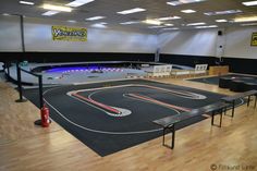 an indoor race track is set up in the middle of a room with tables and benches