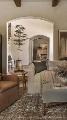 a living room filled with furniture and a tree in the middle of it's center