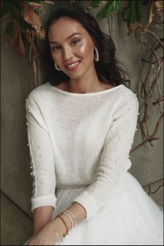 a woman in a white dress is smiling