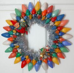 a wreath with christmas lights hanging on the front door