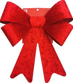 a large red bow on top of a card board with a tag attached to it