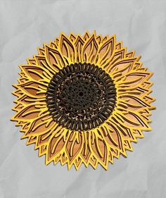 a gold and black metal sunflower on a white background with some brown paper in the foreground