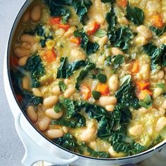 a pot filled with white beans and spinach