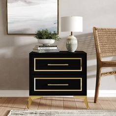 a black and gold nightstand with two drawers in front of a painting on the wall