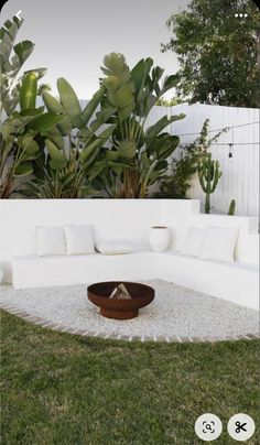 a white couch sitting on top of a lush green field