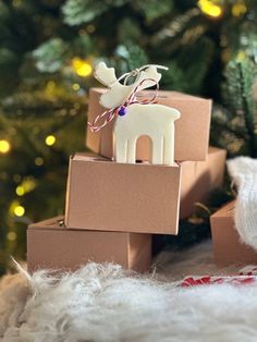 three boxes stacked on top of each other in front of a christmas tree with a reindeer ornament