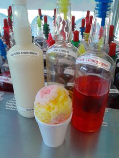 three different types of drinks are on the table next to bottles and containers with liquid in them