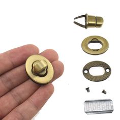 a hand holding an open brass door knob and some screws, nuts and washers