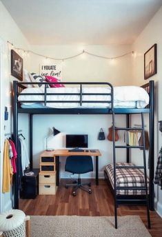 a loft bed with desk underneath it in a bedroom next to a wall mounted computer