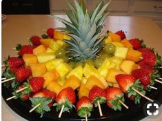 a fruit platter with strawberries, pineapples and grapes