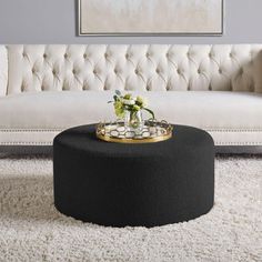 a white couch sitting next to a table on top of a rug