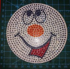 a white plate with a face made out of beads