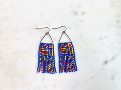 These geometric design is fun and creative! the colors are bold and the triangle adds a little bit of whimsy!  These earrings are made with delicate Miyuki Delica beads and each bead is hand woven. These are super light.  The ear wire is base metal and is nickel and lead free. Please let me know if I can answer any questions. These can be customized to your preference of color! Visit my Etsy shop for more: https://etsy.me/3my7URS Length - 1.7/8 inches Drop length - 2.3/8 inches Width - 1.1 inche Blue Bohemian Triangle Earrings, Bohemian Blue Triangle Earrings, Bohemian Blue Geometric Earrings, Earrings Triangle, Miyuki Delica Beads, Boho Modern, The Triangle, Delica Beads, Modern Boho