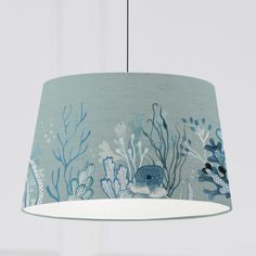 a blue lamp shade with an underwater scene on the bottom and corals printed on it