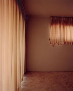 an empty room with drapes hanging from the ceiling