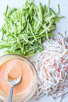 an assortment of vegetables and sauces on a white surface