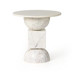 a white marble table with two stacked pedestals