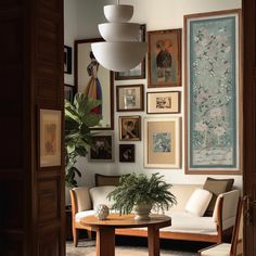 a living room filled with furniture and framed pictures on the wall above a coffee table