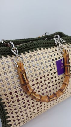 a handbag made out of bamboo and crochet with a purple tag on the handle