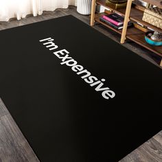 a black area rug with the words i'm expensive on it in white letters